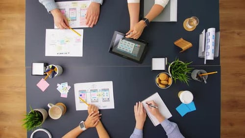Business, People and Team Work Concept - Team of Startuppers with Gadgets