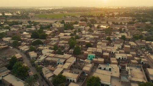 Survol aérien du village de Sher Shah à Multan dans une brume dorée au coucher du soleil