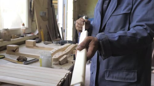 Man Gluing Pieces of Wood Together in Workshop