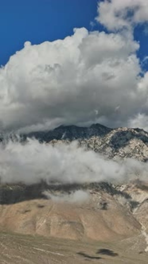 Aerial view of Nevada mountains with clouds and dusty terrain