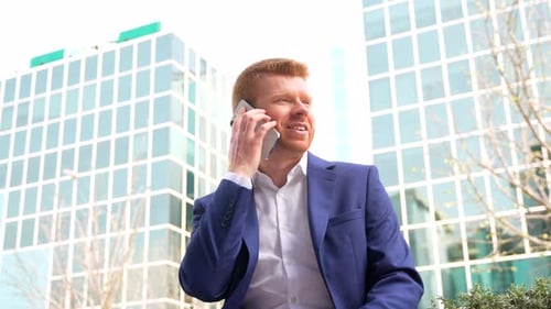 Smiling Man Talking on Phone in City Business District