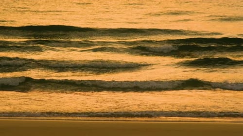 Wellenplätschern bei Sonnenaufgang oder Sonnenuntergang an einem tropischen Strand.