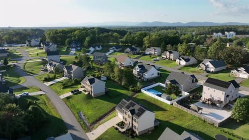 Two-story Single family homes with solar panels on roof in green suburbia of town. Aerial rising
