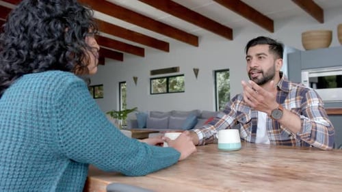 Couple Conversing at Wooden Table in Bright Home