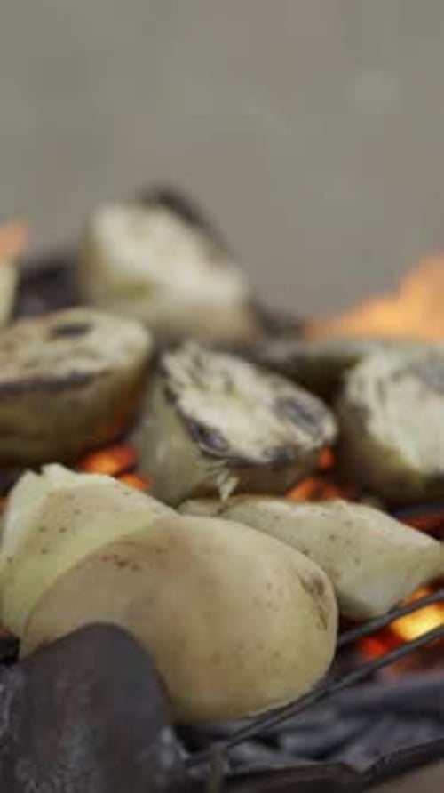 Outdoor Grilling of Potatoes Over an Open Flame Creates a Rustic and Appetizing Scene Flames Dance