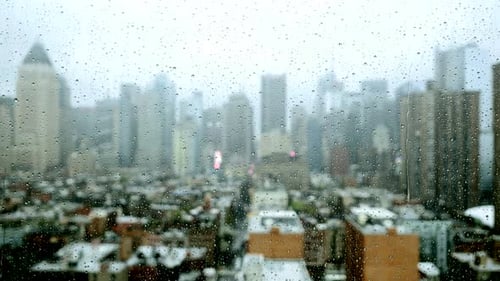 Raindrops on Window with Out-of-Focus City View
