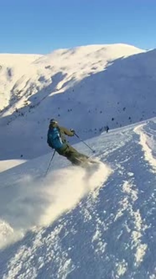 Skier Enjoys the Thrill of OffPiste Skiing in Deep Powder on a Beautiful Sunny Winter Day