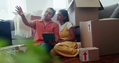 Young Couple Planning Move with Tablet Indoors