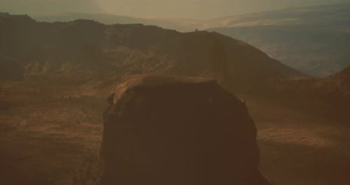 Natural Landscape Featuring Rocky Terrain and Distant Hills During Sunset