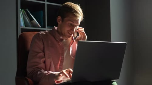 Smiling Young Man Remote Working or Studying at Home Office During Siting on Couch at Desk with