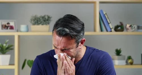 4k video footage of a handsome middle aged man suffering with the flu at home