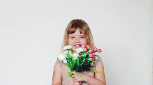 Smiling Child Holds Artificial Flower Bouquet