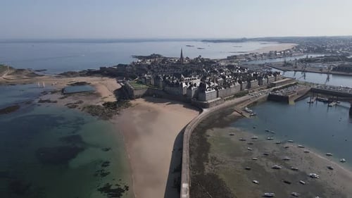 Plage du mole or pier beach with Saint-Malo in background, Brittany in France. Aerial backward. Sky