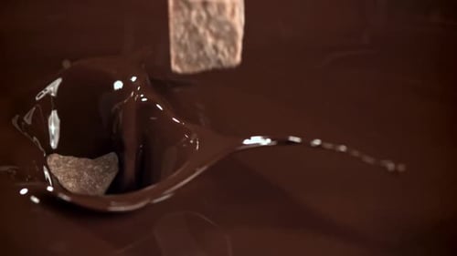 Pieces of Chocolate Fall Into the Melted Chocolate Filmed on a Highspeed Camera at 1000 Fps