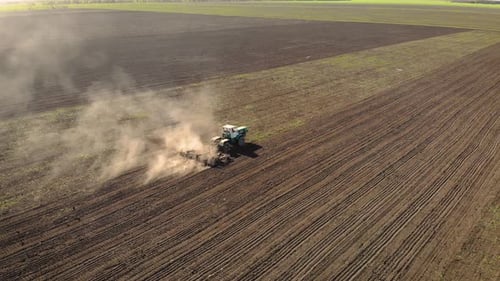 Aerial Birds Eye View Footage of Tractor Plowing Fields with Plough Before Sowing Sunflower