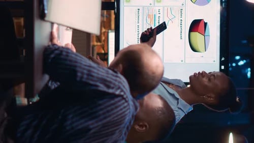 Business Team Analyzes Data in Evening Meeting