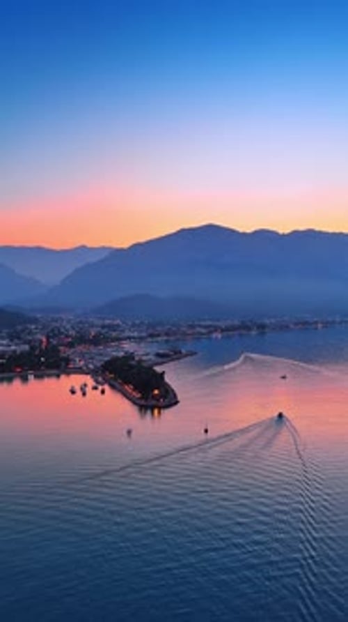 Approaching the beautiful pier of the lovely coast of the sea. Mountain silhouettes at backdrop.