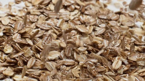 Oatmeal falling in slow motion onto white surface