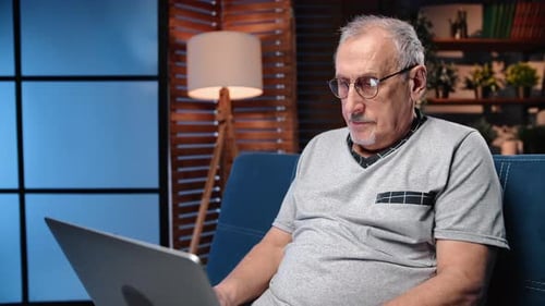 Senior Man Using Laptop Computer at Home