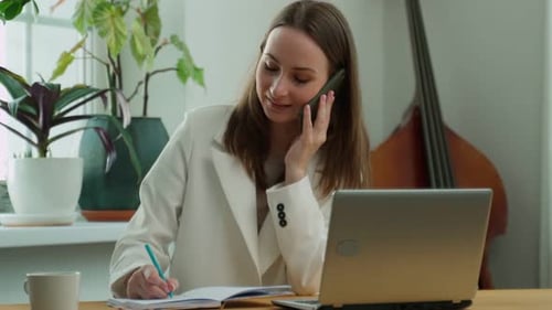 Portrait of a Young Business Woman Doing Business in the Office at the Workplace Recording Some