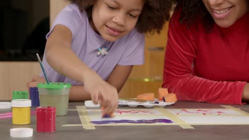 Closeup of Happy School Age African American Girl Sponge Painting Picture