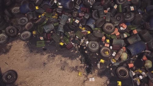 Littered Land Filled with Discarded Barrels and Debris on a Deserted Area