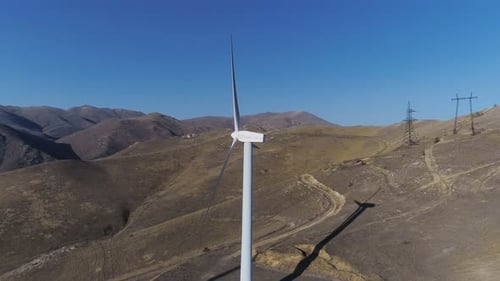Wind turbine blades smoothly circling on a sunny day at an infinite wind farm