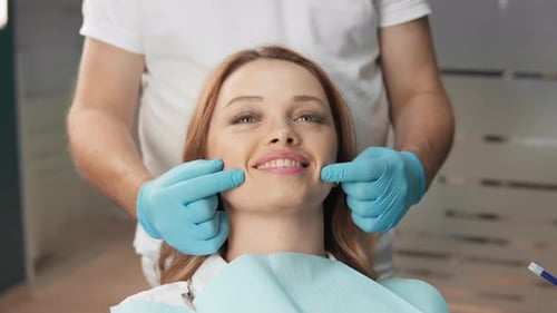 Dental Patient Smiling During Examination by Dentist