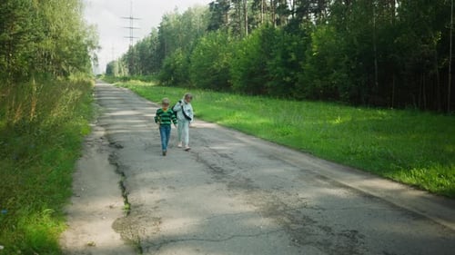 Little Children Walking Home Along Quiet Forest Road