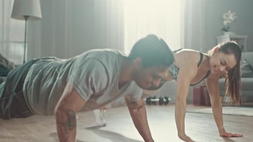 Couple does pushups together at home for fitness