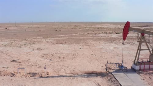Drone Flying Past Oil Pumpjack in Desert Oilfield