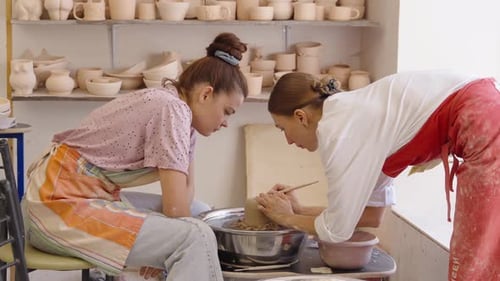 Two Artists Collaborate on Pottery Creation in a Workshop Setting