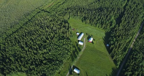 Topdown drone-shot of a house surrounded by a vast forest.