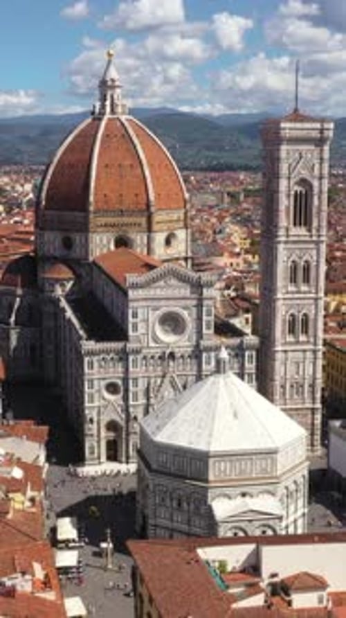 Vertical drone spinning around amazing Cathedral of Santa Maria del Fiore and city on a sunny day