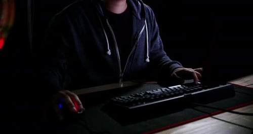 Young Adult Using Computer in Dark Room