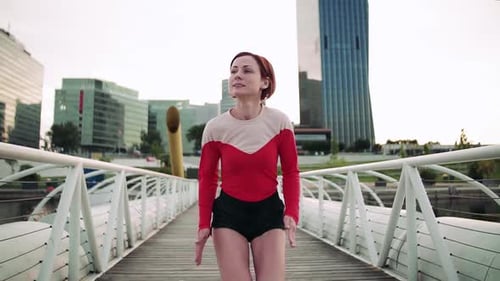 Young woman doing cardio workout on urban bridge in the city outdoors