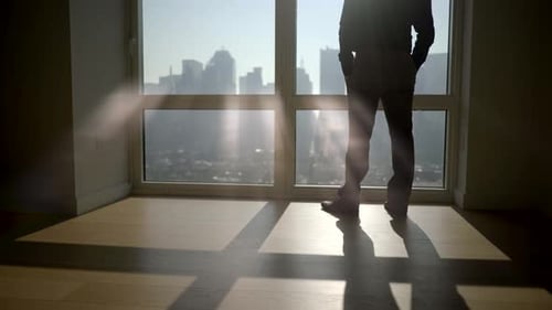 Young Successful Man Living in High Rise City Apartment With Skyline View