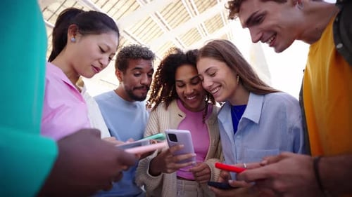 Group Multiracial Young People Gathered in Circle Using Mobile Laughing and Looking in Smart Phones
