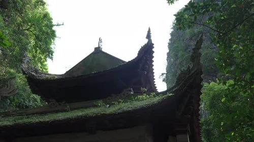 Low-angle view of ancient Bích Động Pagoda in Ninh Bình, Vietnam, surrounded by green nature and