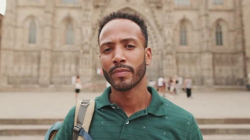Close-up of young man tourist with backpack on his shoulder, looking at the sights