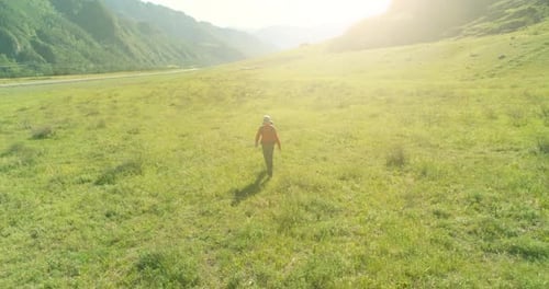 Flight Over Backpack Hiking Tourist Walking Across Green Mountain Field