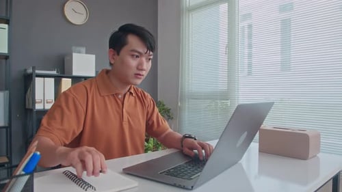 Young Developer Working on Laptop at Office Desk