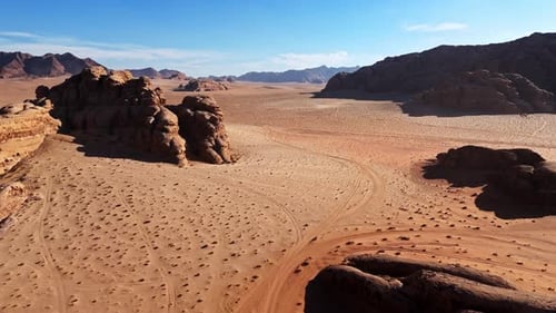 Drone shot of vast sandy plains and sandstone mountains in Wadi Rum Jordan