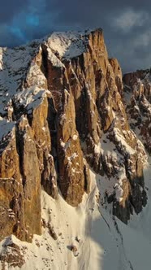 Rocky snow mountains at sunset aerial