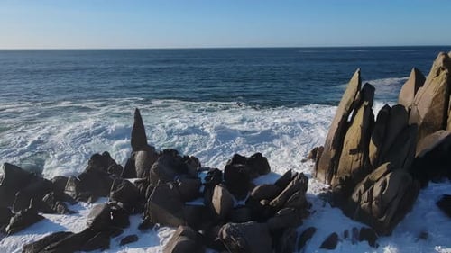 Rocky Shoreline By a Vast Body of Water Under a Cloudy Sky