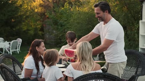 Family Enjoys Watermelon Together in Rural Setting