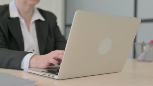 Close up of Old Businesswoman Typing on Laptop