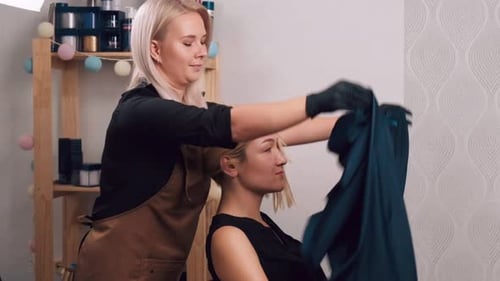 Hairdresser Arranging Cape on Blonde Haired Client