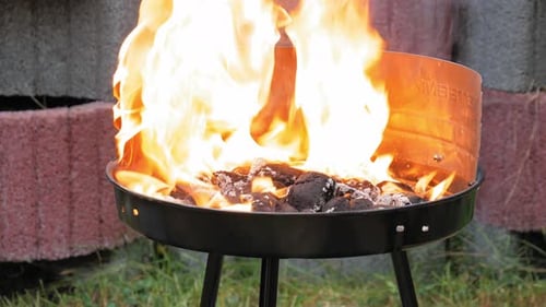 Lighter Fluid Being Squirted On Barbecue Grill - close up