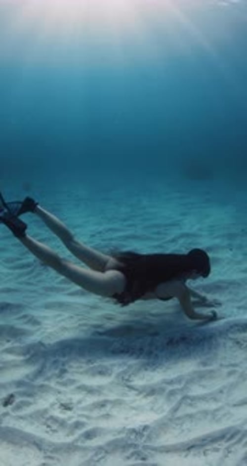 Freeder Woman with Perfect Body Swimming Underwater in Transparent Sea